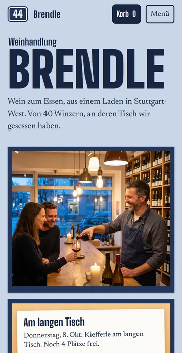 Startseite der erfundenen Weinhandlung Brendle: großes Ladenschild „Brendle“, im Schaufenster schenkt Martin an der Holztheke Rotwein ein, an der Tür hängen Zettel zum Weinabend und zu den Öffnungszeiten