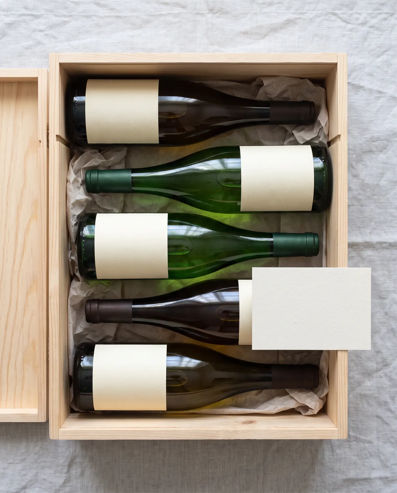 Holzkiste mit fünf Flaschen Wein
